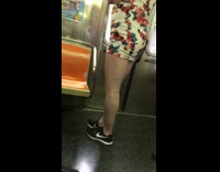 Guy riding train wears short white dress