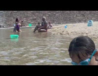 Man with necklaces sit pose on beach