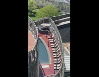 Woman in bikini with a hat poses by the poolside