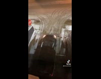 Cars trying to get up snow covered ramp 