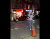 Man plays golf along the street at night in new york 