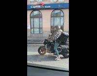 Guy pulls friend motorcycle on the street