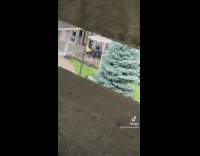 Guy in parking structure screams and moans at people at tables