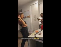 Guy in black shirt watching girl sing and rap party kitchen 