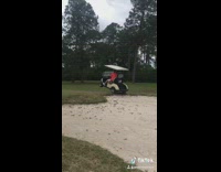 Man drives golf cart over sand bump