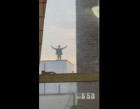 Man stands on roof with arms wide open