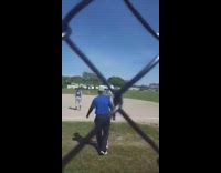 softball player in blue uniform falls running on field