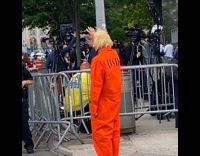Person wearing trump mask and prison jumpsuit 