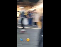 Man feeds pigeon flock at subway platform