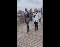 Woman poses and takes photos on the Brooklyn bridge 