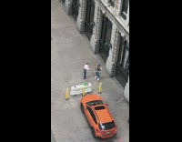 Guy hoodie jacket orange car grey building