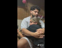 Lady Clenches Fist as Man Hugs Her