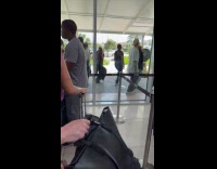 Group dances outside the airport lobby window