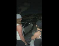 Two guys trying to see cold breath point at house 