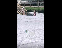 Woman on knees on beach next to stairs