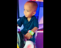 Kid smirks while riding carousel 