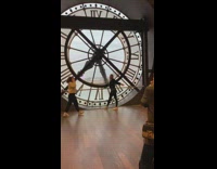 Woman takes picture in front of large clock