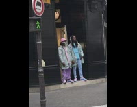 Two guys colorful pastel outfits black building 