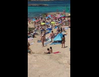Woman in bikini with a cap poses at the beach