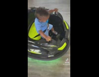 Baby riding spinning bumper cart in house 