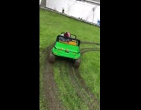 Little boy falls asleep while riding green and yellow toy truck, truck driving in circles in the grass