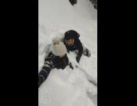 Two people jump into snow and play with snow