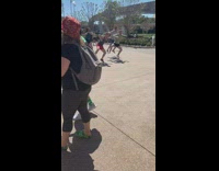 Four people dance at flower garden sign