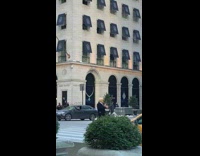 Guy wears suit and trump costume mask