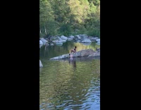 Woman bikini hair flip on rock river pictorial