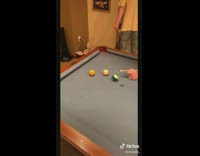 Guy laying on pool table misses cue ball