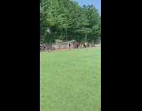 Soccer player in yellow jersey kicks ball into guys crotch with blue jersey