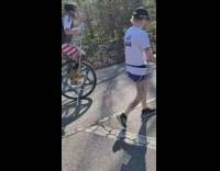 Guy wearing american flag shorts rides unicycle