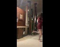 Woman black hat bra white wall bottles