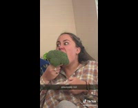 Woman eating a whole head of broccoli with ranch