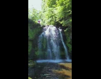 Drone shot waterfalls guy sit on ledge