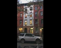 Black dog pointy ears looks outside apartment window on second floor silhouette 