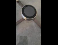 Guy spins nest thermostat on glass table 