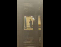 Guy practicing clarinet on the opposite subway train platform 
