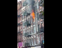 Fireman beside the building window on fire