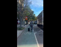 Man riding citibike while dragging luggage
