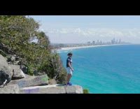 Guy stand rock cliff dolly zoom beach