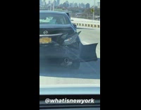Black car drives on freeway with broken bumper falling off