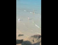 Man beach walk towards woman that films