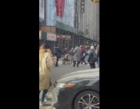 Rat mask guy dancing with people at crosswalk