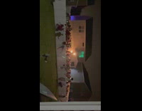 People running from party jumping over white fence 