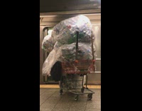 orange shopping cart full of cans coming out of train