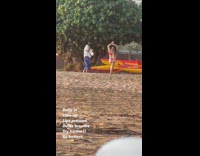 Woman red bikini hands up sunset beach