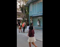 Girl white skirt blue building striped shirt