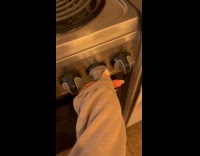 Woman turns stove knob switching lights on