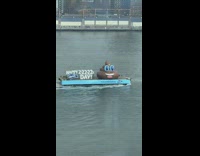 Giant inflatable poop emoji on a barge in the river